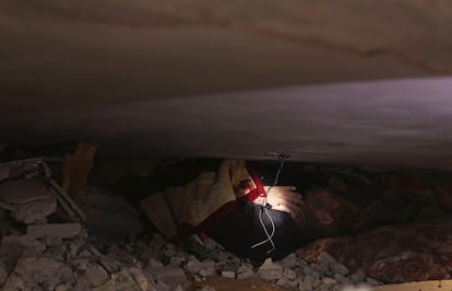 Un hombre atrapado bajo los escombros de un edificio bombardeado por el ejército israelí, este domingo en Rafah, en el sur de Gaza.