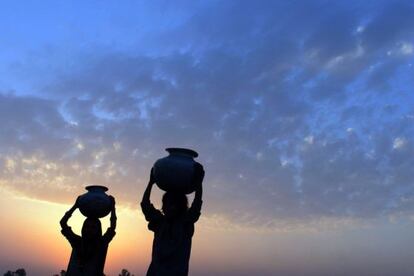  J&oacute;venes paquistan&iacute;es transportan c&aacute;ntaros durante un atardecer en Lahore (Pakist&aacute;n) 