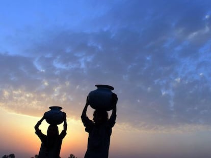  J&oacute;venes paquistan&iacute;es transportan c&aacute;ntaros durante un atardecer en Lahore (Pakist&aacute;n) 