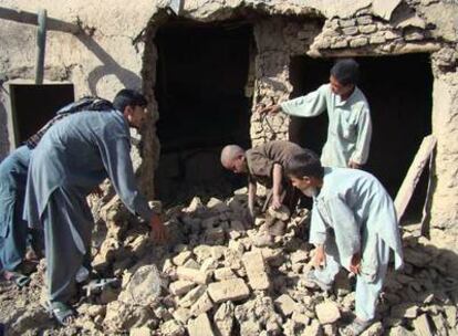 Ciudadanos afganos en los restos de una casa alcanzada por el ataque de la OTAN