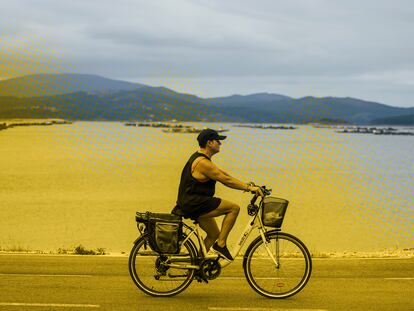 Una mujer pasea en bicicleta frente a la Ría de Arousa, el 26 de julio.