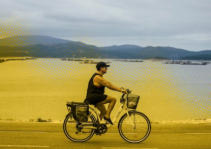 Una mujer pasea en bicicleta frente a la Ría de Arousa, el 26 de julio.