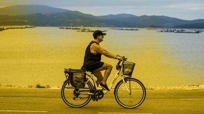 Una mujer pasea en bicicleta frente a la Ría de Arousa, el 26 de julio.