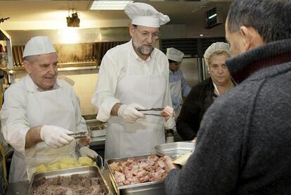 Rajoy, sirviendo comida en un centro de acogida de Madrid en 2009. / EFE