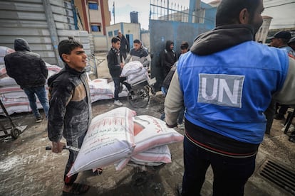 Unos trabajadores palestinos de la UNRWA reparten harina a desplazados por la guerra en la ciudad meridional de Rafah, en Gaza, el 28 de febrero de 2024.