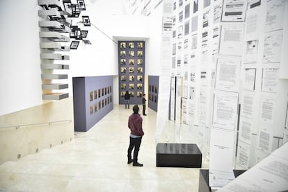 Un asistente observa los archivos desclasificados que caen como sábanas.
