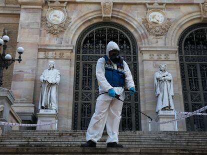 Un profesional trabaja en la desinfección y limpieza de la entrada de la Biblioteca Nacional, hoy en Madrid.