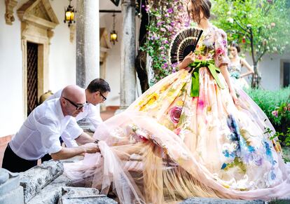 Domenico Dolce y Stefano Gabbana terminan uno de los vestidos de su primer desfile de Alta Moda, que tuvo lugar en Taormina en 2012.
