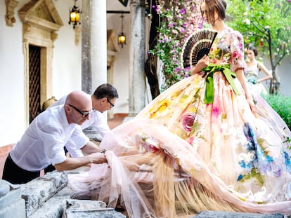 Domenico Dolce y Stefano Gabbana terminan uno de los vestidos de su primer desfile de Alta Moda, que tuvo lugar en Taormina en 2012.