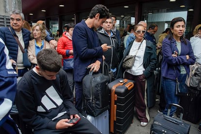 Viajeros esperan para poder coger un tren de alta velocidad a las afueras de la estación de Atocha en Madrid, este lunes.