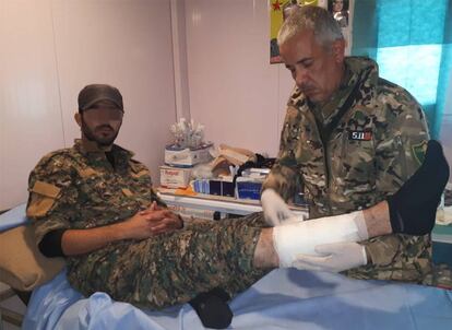 El Doctor Delil atendiendo a un miliciano kurdo herido en su dispensario del campamento de Ahmud, en Sinjar (Irak).