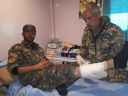 El Doctor Delil atendiendo a un miliciano kurdo herido en su dispensario del campamento de Ahmud, en Sinjar (Irak).