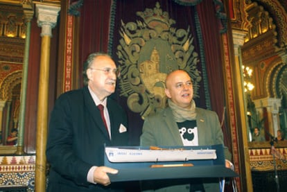 Iñaki Azkuna (izquierda) recibe una reproducción de una trainera donostiarra que le entrega Odón Elorza en el Ayuntamiento de Bilbao.