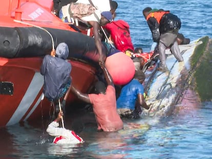 Varios emigrantes que viajaban en una patera en el agua tras volcar la embarcación frente al puerto de La Restinga, este miércoles en la isla de El Hierro.