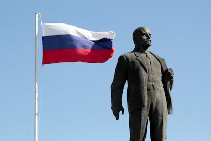 La bandera rusa ondea junto a una estatua de Lenin en Bakhchysarai, Crimea.