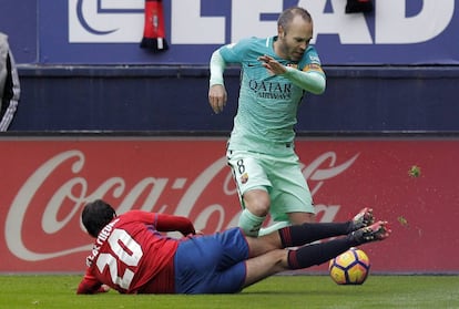 El centrocampista del Barcelona Andrés Iniesta disputa un balón con el centrocampista del Osasuna Miguel de las Cuevas.