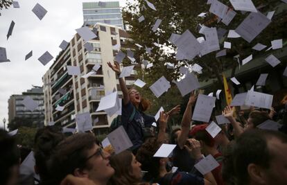 Una joven lazan papeletas del referéndum durante la protesta frente a la sede del Partido Popular en Barcelona.