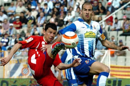 El delantero serbio del Atlético de Madrid Kezman chuta el balón en presencia del defensa del Espanyol Alberto Lopo.