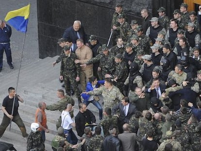 Ativistas entram em confronto com policiais na porta do Parlamento em Kiev.