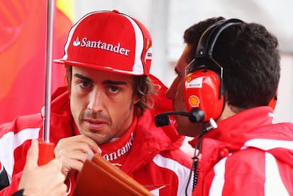 Fernando Alonso intercambia impresiones con un técnico de Ferrari en una pausa de los entrenamientos para el GP de Alemania.