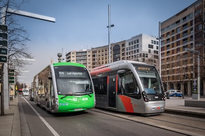 Uno de los nuevos autobuses eléctricos de Zaragoza, al lado de un tranvía.