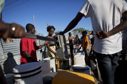 La gente espera en la fila para llenar baldes con agua a una bomba en Canaán, Haití. Los residentes dicen que esta bomba, como la mayoría de las de Canaán, da un agua que es demasiado salada para beber. Los residentes la utilizan para el lavado y limpieza