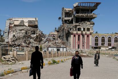 People walk in front of the remains of the University of Mosul, which was burned and destroyed during a battle with Islamic State militants, in Mosul, Iraq, April 10, 2017. Marko Djurica: "On April 10, a Reuters team entered eastern Mosul to work on a story about the the city's destroyed university, once a centre for education in northern Iraq.ÊOn arrival, I was struck first by the huge size of the campus, then by the scale of destruction.ÊAt least 10 large buildings and some smaller ones had been more or less reduced to rubble. The entrance was guarded by Iraqi soldiers, cleaning their guns and drinking tea.ÊI saw people trying to carry furniture and equipment out from what was once the chemistry department in a burnt-out building.ÊIt turned out these men were professors who had taught there and had now volunteered to save whatever could be salvaged.ÊAs I walked around taking pictures I met more teachers trying to clean up or just gloomily contemplating the devastation. It was emotional for them as they knew there was no chance the university would be the same again anytime soon." REUTERS/Marko Djurica/File photo   SEARCH "MOSUL PICTURES" FOR THIS STORY. SEARCH "WIDER IMAGE" FOR ALL STORIES.?