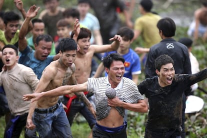 Varios lugareños celebran la victoria tras coger el 'Phet', una bola de bambú roja que simboliza el sol, durante la celebración del Festival Cuop Phet con motivo de las celebraciones del Año Nuevo Lunar en la provincia de Phu Tho (Vietnam).