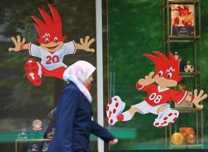 Una mujer pasa frente a un escaparate con las mascotas de la Eurocopa.