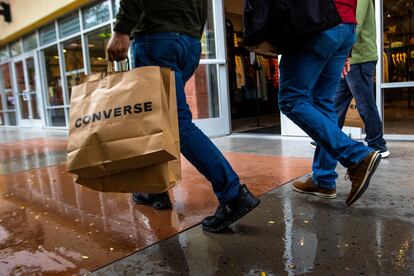 A shopper carries multiple bags while walking with others on Tuesday, March 14, 2023, in Las Vegas. On Wednesday, the Commerce Department releases U.S. retail sales data for February.