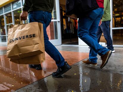 A shopper carries multiple bags while walking with others on Tuesday, March 14, 2023, in Las Vegas. On Wednesday, the Commerce Department releases U.S. retail sales data for February.