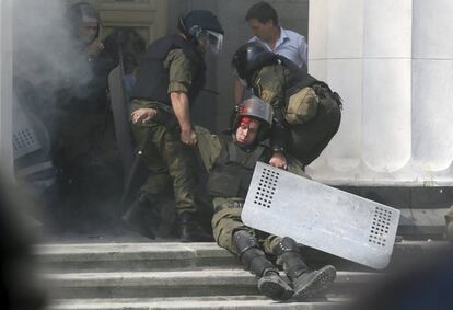 Un miembro de la Guardia Nacional ucraniana ha muerto en los enfrentamientos que han tenido lugar junto a la Rada Suprema (Parlamento) en Kiev. El conflicto ha dejado cerca de un centenar de heridos entre los miembros de las fuerzas de seguridad, según informó el ministro del Interior ucraniano, Arsén Avákov. En la imagen, un herido es trasladado al interior del Parlamento.