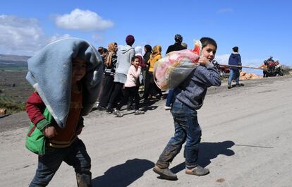 "Se dirigieron a los centros instalados por el gobierno sirio y la Medialuna Roja rabe siria, refugios temporales equipados de todo el material necesario para hacerse cargo de ellos", a?adi. . En la foto, ni?os sirios portan objetos personales a cuestas mientras abandonan Guta Oriental, el 16 de marzo de 2018.