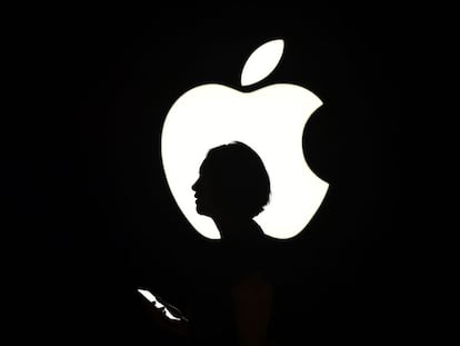 Una mujer pasa delante de un cartel con el logo de Apple en San Francisco, en septiembre de 2015. 