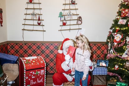 David Prados, atendiendo a una niña que ha venido a conocerle en la Casa de la Navidad de Torrejón de Ardoz.
