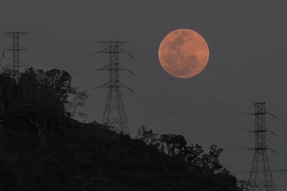 La luna llena se levanta sobre el parque nacional El Ávila en Caracas (Venezuela) durante el eclipse total lunar del 15 de mayo de 2022. La cercanía de objetos en el horizonte la hace parecer más grande.
