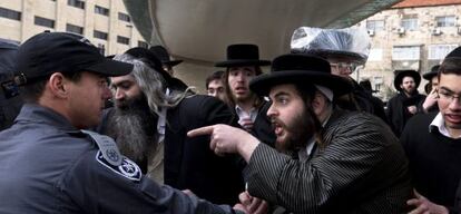 Un jud&iacute;o ultraortodoxo se&ntilde;ala a un polic&iacute;a durante una protesta en Jerusal&eacute;n. 