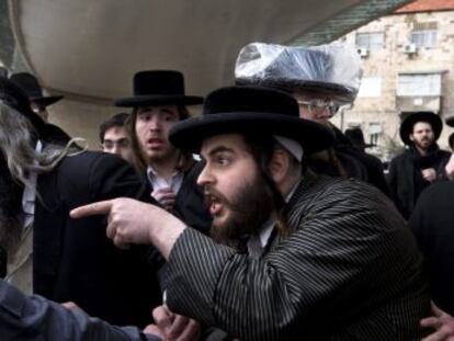 Un jud&iacute;o ultraortodoxo se&ntilde;ala a un polic&iacute;a durante una protesta en Jerusal&eacute;n. 