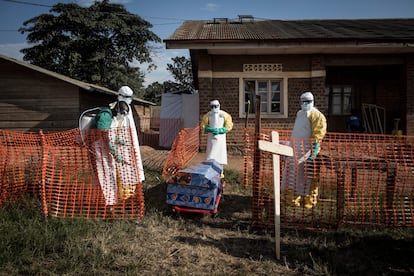 Agentes sanitários desinfetam um caixão durante enterro seguro em agosto de 2018 na localidade de Beni, nordeste do Congo.