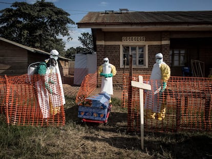 Agentes sanitários desinfetam um caixão durante enterro seguro em agosto de 2018 na localidade de Beni, nordeste do Congo.