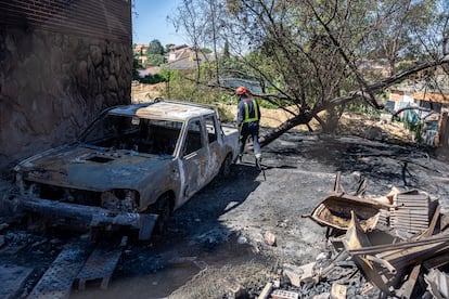 Un coche antiguo, devorado por el fuego, en la urbanización afectada.