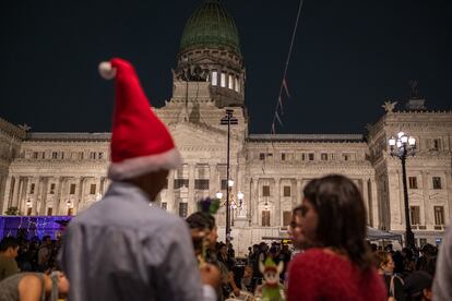 Personas esperan la llegada de la cena y la entrega de regalos de Papá Noel.