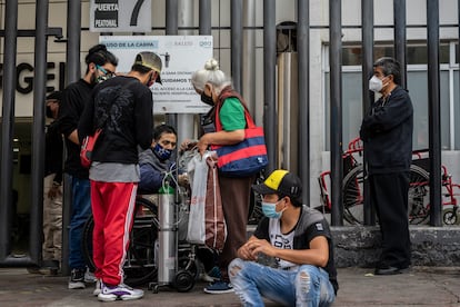 Un enfermo de covid-19 en silla de ruedas es atendido por sus familiares después de haber sido rechazado en un hospital de Ciudad de México.