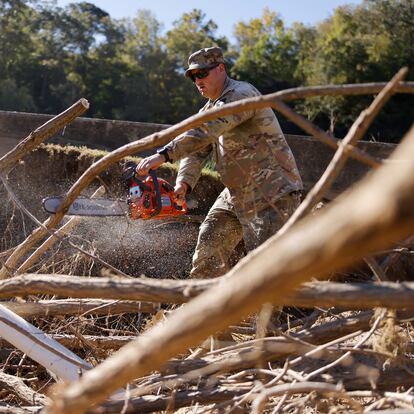 A U.S. soldier cuts away fallen tree debris on the banks of the French Broad River in the wake of Hurricane Helene, Oct. 10, 2024.