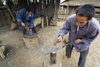 Luong y su primo dan forma a una hoz que han fabricado con m&eacute;todos tradicionales utilizando metales reciclados de proyectiles. La vender&aacute;n a vecinos o en el mercado y obtendr&aacute;n m&aacute;s beneficio que vendiendo el metal a peso en la chatarrer&iacute;a.