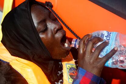 Una mujer rescatada bebe agua fresca ofrecida por los activistas de la ONG.