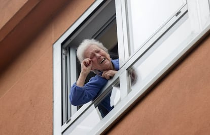 Carmen, vecina del concello coruñés de Cambre, celebra por la ventana el Gordo que ha tocado en el bar de debajo de su casa.