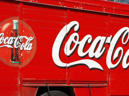 Un hombre bajando de un camión cajas de Coca-Cola