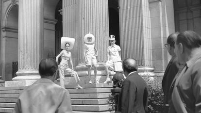 Lourdes Albert, a la derecha, y otras dos modelos posan con diseños de Antonio Nieto en la escalinata del madrileño palacio de la Bolsa en abril de 1967, mientras algunos curiosos se detienen a observar la escena.