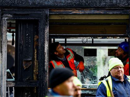 Trabajadores inspeccionan uno de los vagones de tranvía incendiados durante los disturbios violentos de este jueves en Dublín